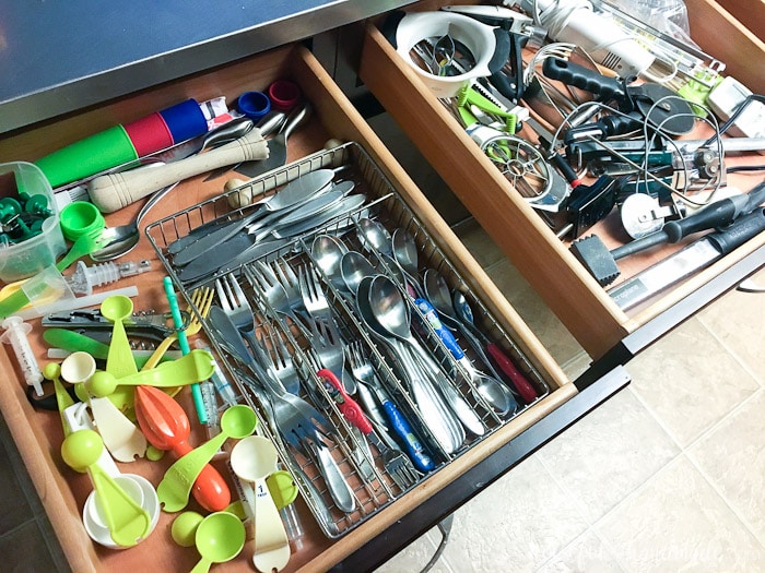 kitchen drawers full of utensils before organizing with vinyl kitchen utensil drawings