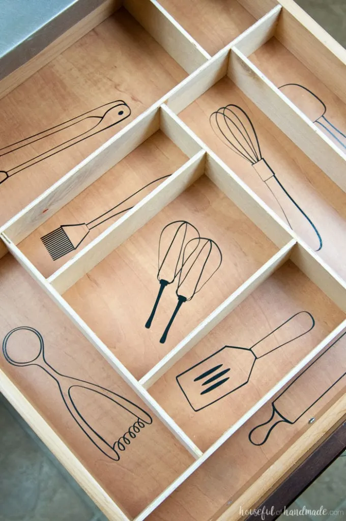 Kitchen drawers organized with vinyl labels that look like the kitchen utensils. 