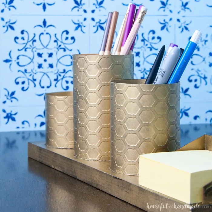 I love this painted brass DIY desk organizer to keep your favorite things organized on your desk. This organizer is made to look like brass with a beautiful chicken wire pattern, but you will never guess what it is actually made out of. Housefulofhandmade.com | Spellbinders | Embossing Plate | Brass Spray Paint | Paper Crafts | Desk Organization | Pencil Holder | Chic Desk Accessories | Farmhouse