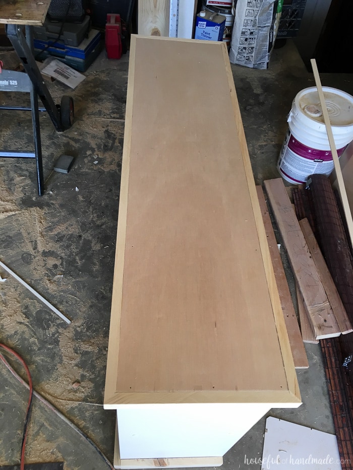 Adding trim to the wood top on the bookcase. 