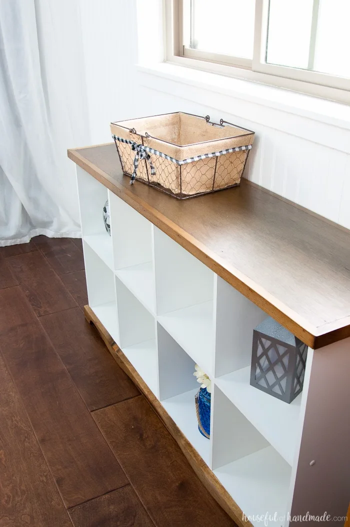 Over head view of a bookcase console table with white shelves and a wood top/base. 