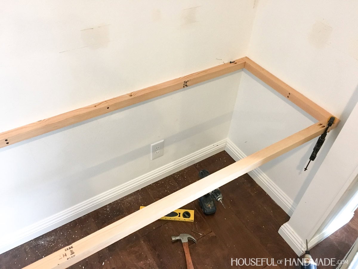 Desk frame attached to closet with 2x2 boards and pocket holes screwed to the ends.