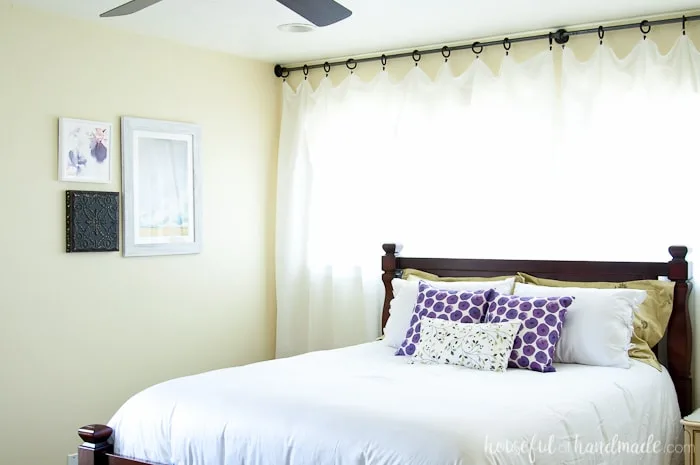 See how easy it is to complete a Master Bedroom Makeover in a weekend. A handful of simple projects can make your bedroom look bigger and brighter. Housefulofhandmade.com | Weekend Makeover | Bedroom Refresh | White Curtains | White bedding | Bed pillows | Bedroom Art | Roman Shades