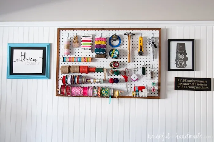 Framed pegboard storage for craft supplies on the wall. 