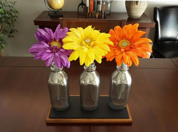 Ways to Upcycle Glass Jars & Bottles: Mirrored Milk Bottle Centerpiece from Small Home Soul.