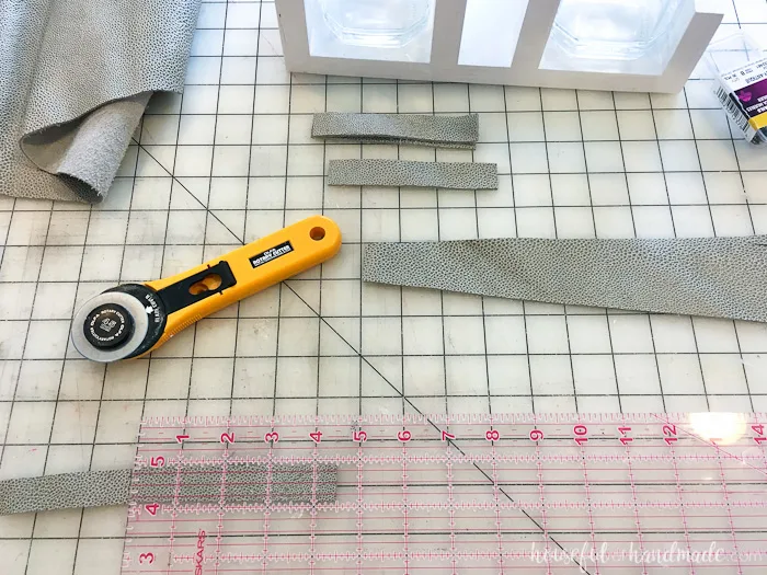 Cutting scraps of leather to hold the mason jars in the utensil carrier. 