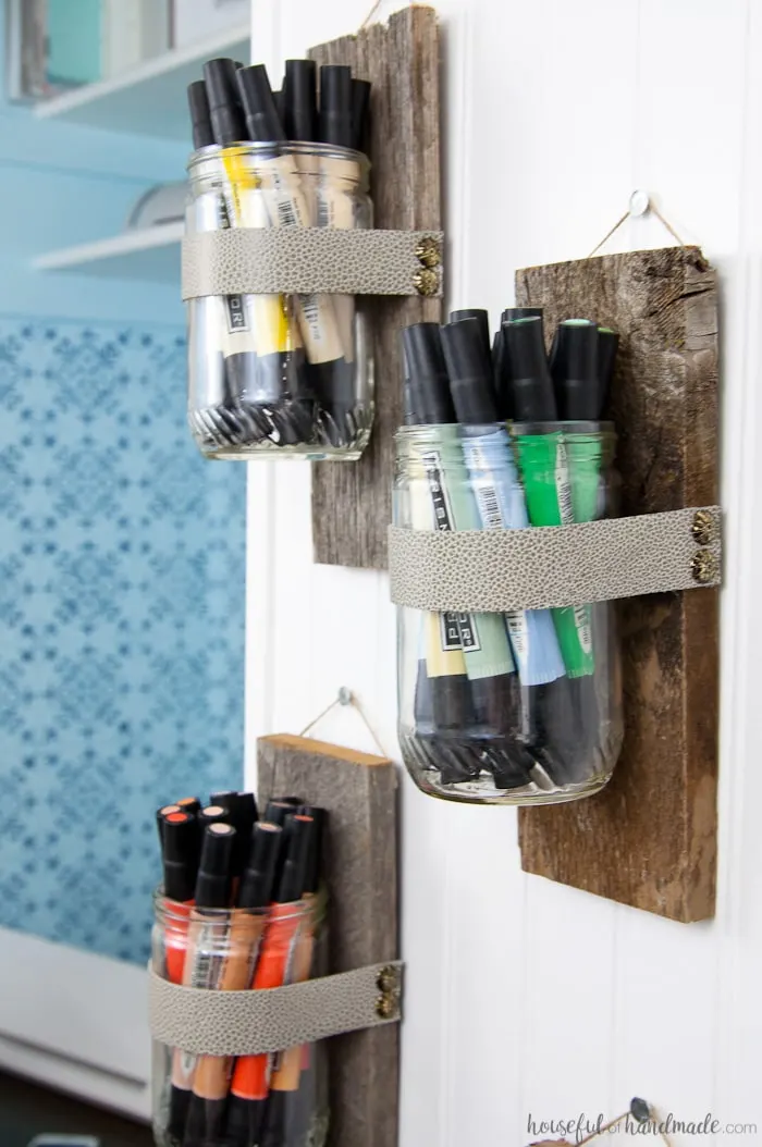 Use these amazing DIYs to Organize your home this year. Upcycle old peanut butter jars into DIY wall vases for the perfect farmhouse decor. Use your wall vases to display art supplies, flowers or herbs. Tutorial from Housefulofhandmade.com | Farmhouse Wall Decor | Rustic Wall Vase | 10 minute Crafts | Reclaimed Wood | Upcycle Ideas | Farmhouse Decor Tutorial | Craft Supply Organization Ideas