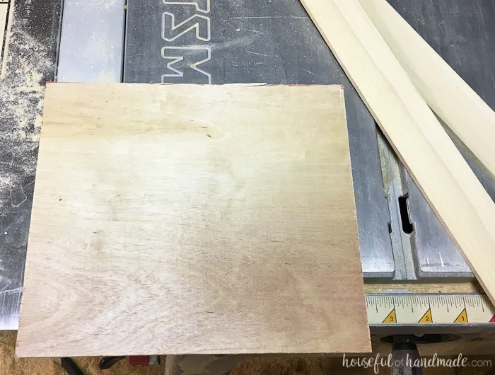 Piece of plywood sitting on a table saw next to 1/4: thick boards.