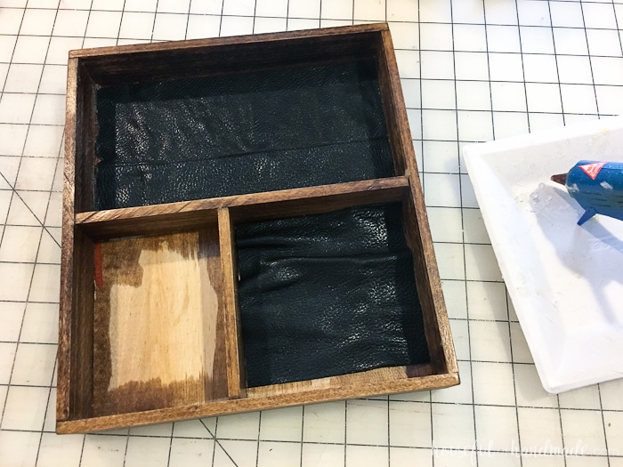 Wood nightstand tray with leather being hot glued into the bottom. 