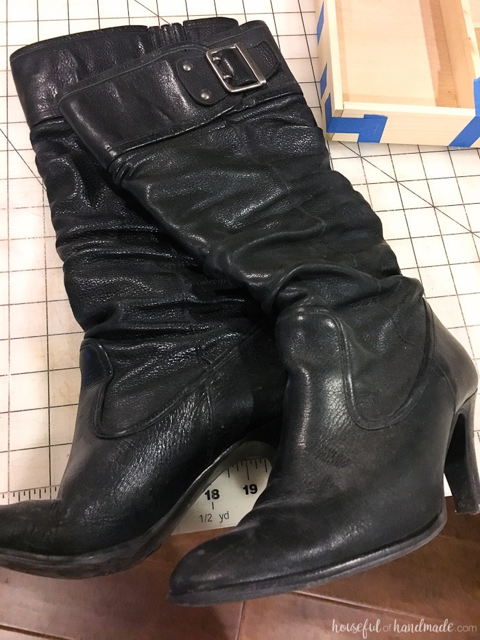 Pair of old boots laying on a cutting mat. 