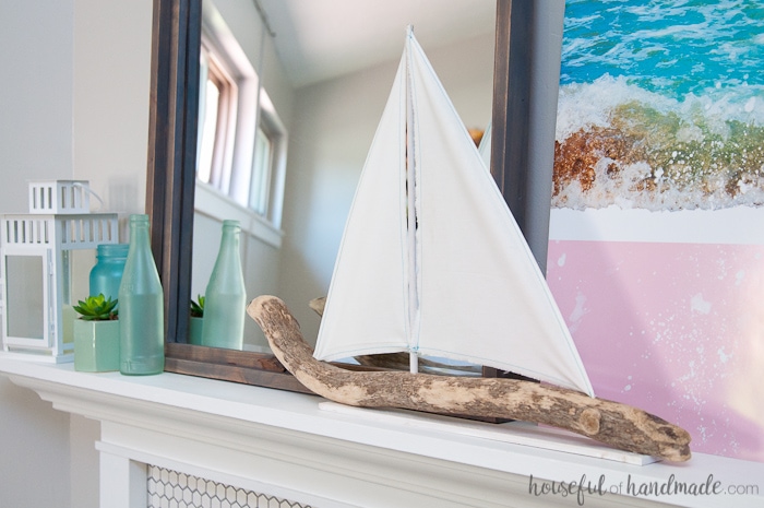 Create the perfect summer mantel decor with "found" beach objects. A DIY driftwood sailboat and mirror are the jumping off point for this soft beach house inspired summer mantel for the Decorate Your Mantel Series. Housefulofhandmade.com | Summer Mantel Inspiration | Beach Mantel Ideas | Sea Glass Decor | Sailboat Decor | DIY Summer Mantel 