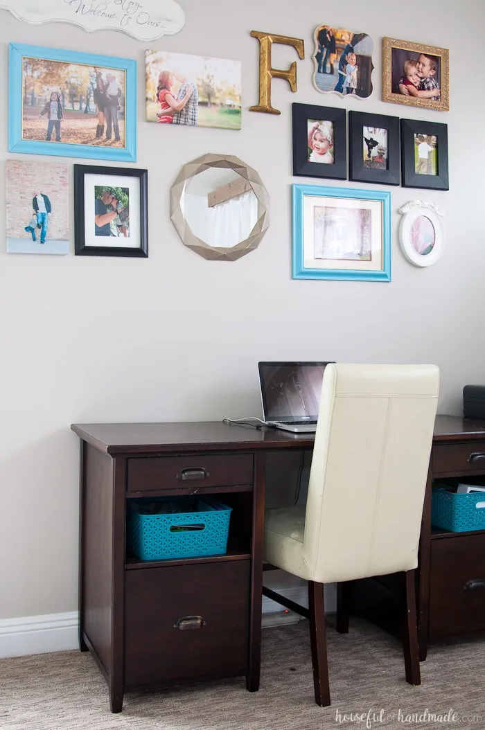 Desk against a wall with picture frames in colors that go with perfect greige