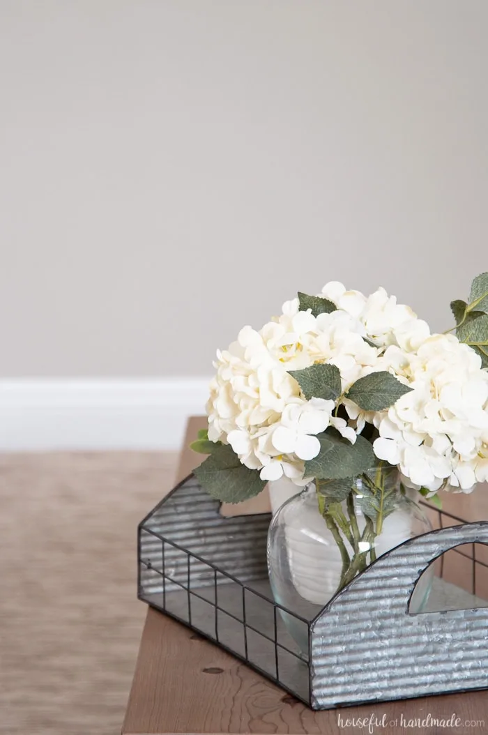 Flower arrangement in room with griege wall.