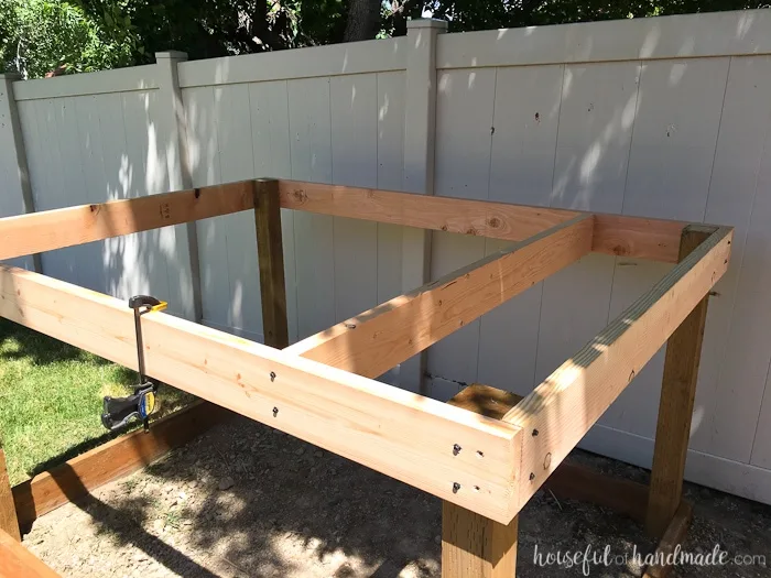 Even though our yard is small, we decided we still needed a DIY playhouse. Check out how we built the small playhouse for our kids, on a budget, starting with the deck. This project was so easy and now we can see the playhouse starting to take shape. Housefulofhandmade.com | How to Build a Playhouse | DIY Swing Set | Small Playhouse | Playhouse Build Plans 