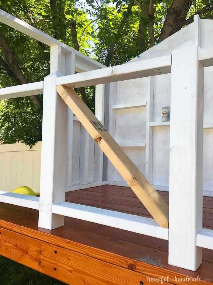 Our DIY Playhouse is coming along! This week we tackled the railing. The beautiful X railing is perfect for the cute cottage playhouse. See how we are building the playhouse step-by-step including free build plans and time/cost breakdown. Housefulofhandmade.com | DIY Playhouse | Playhouse Build Plans | DIY Swing Set | How to Build a Playhouse | DIY Sandbox