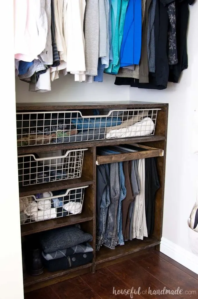 DIY closet organization system with baskets and shelves made from plywood.
