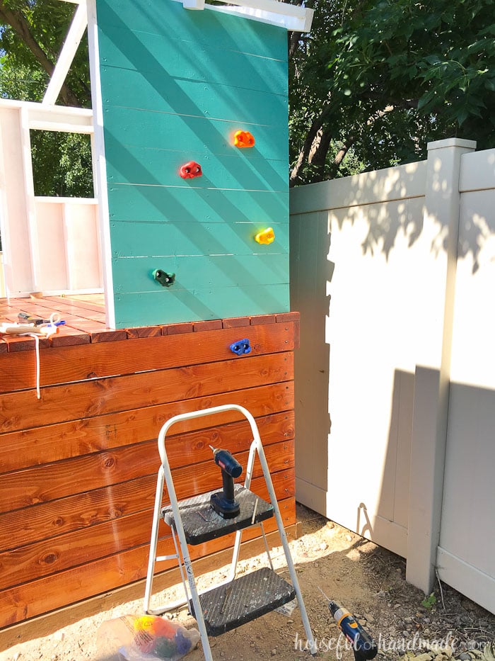 Our DIY playhouse is almost done! This week we are sharing all the details on how we installed the slide and climbing wall to make the playhouse into a kids dream play area. Includes the build plans and cost breakdown for the whole project. Housefulofhandmade.com | How to build a playhouse | DIY swing set | Kids Playhouse | Free Build plans | How to Install a slide 