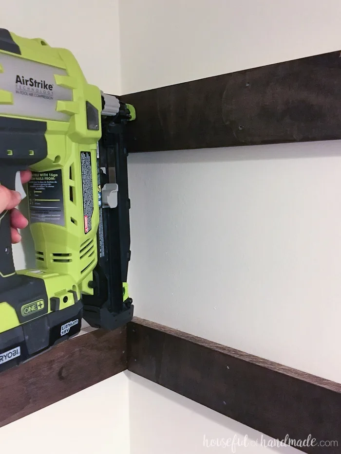 Nailing the shelf supports into the closet with a Ryobi nail gun. 