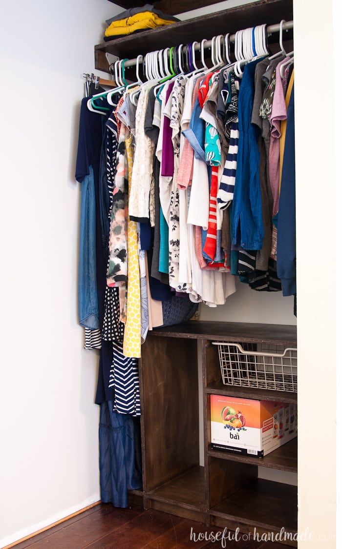 Small closet with DIY plywood shelves on the top and custom closet organizer on the bottom with room for folding items.