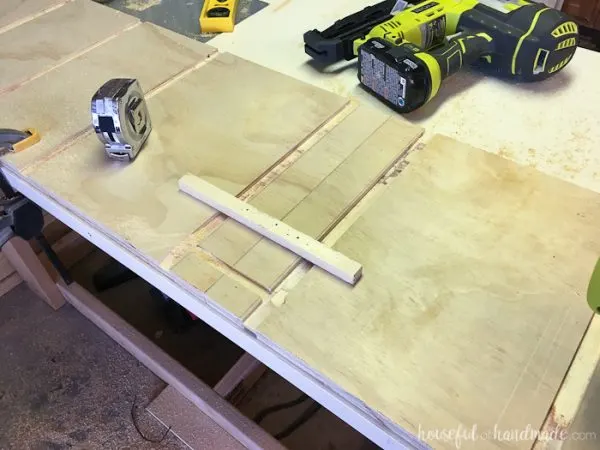 A scrap piece of wood nailed on the board to router the groove for the toe kick.