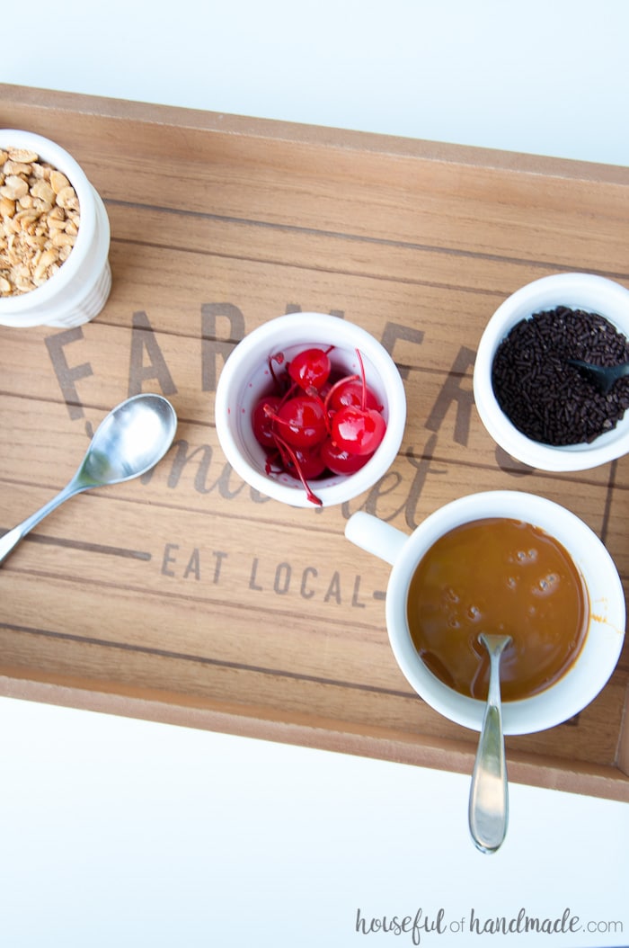 overhead view of toppings for ice cream on a farmhouse tray