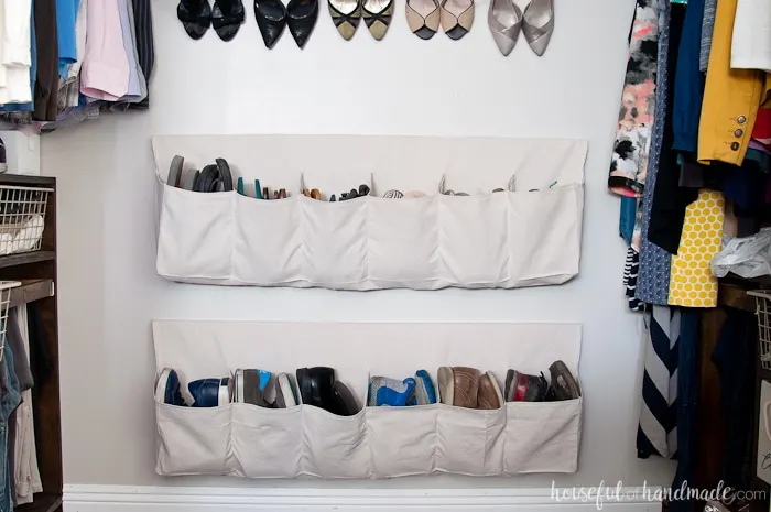 Inexpensive drop cloth hanging shoe storage on the wall in the closet filled with shoes. 