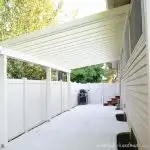 White painted patio pergola attached to the house with angled purlins.
