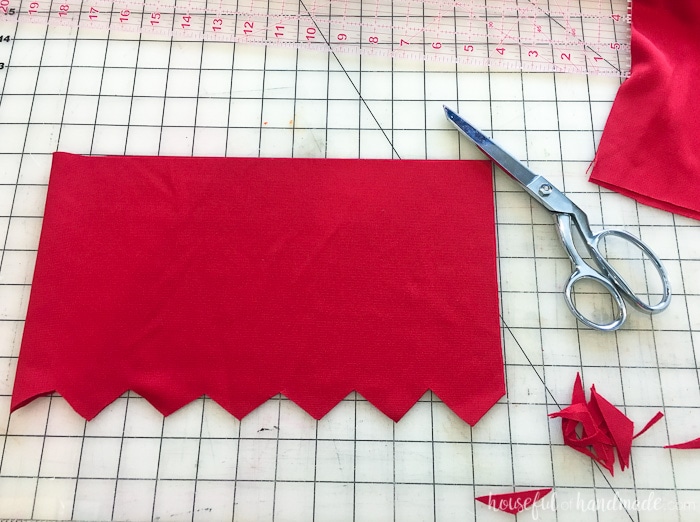Red material shown being cut out with scissors.