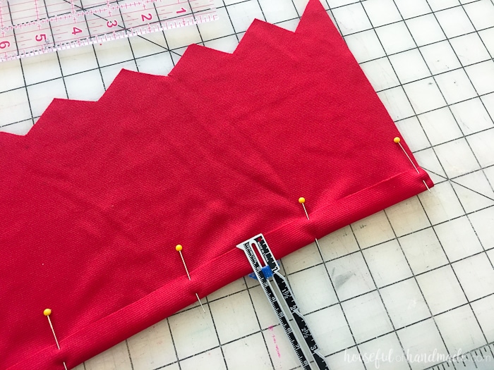 Red material being pined and measured for handmade Moana Costume.