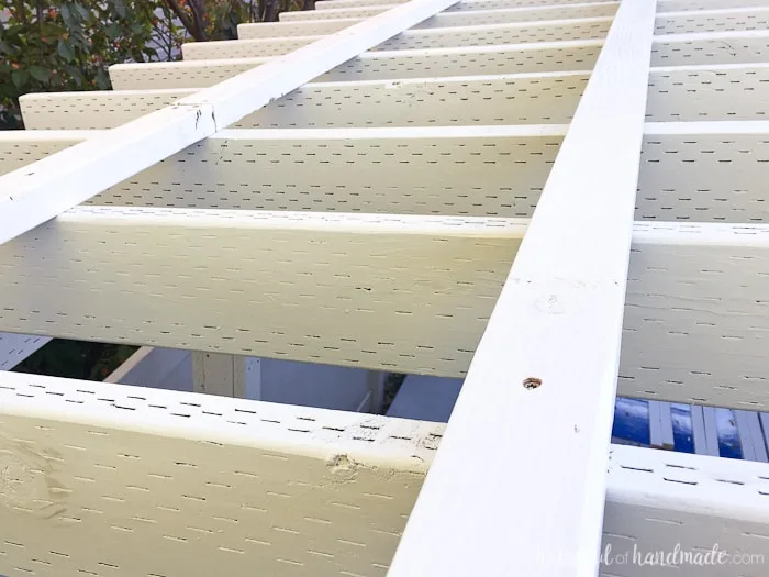Secure 2x3 boards as purlins for the clear pergola roof. Get the full tutorial from Housefulofhandmade.com