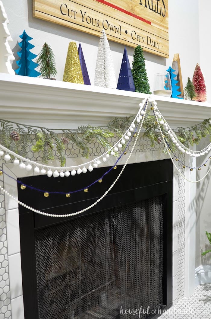 Add garlands to the front of your mantel for beautiful textures. Check out the entire holiday mantel at Housefulofhandmade.com.
