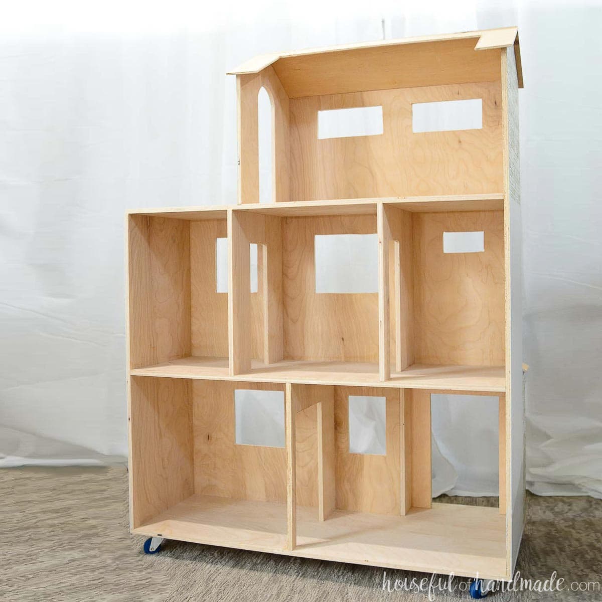 DIY dollhouse for 10" dolls made from plywood with wheels.