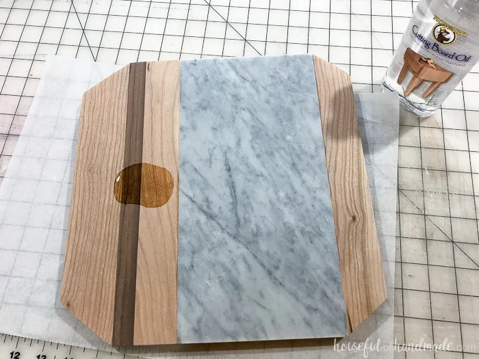 Adding the cutting board oil to the finished marble cheese board. Housefulofhandmade.com