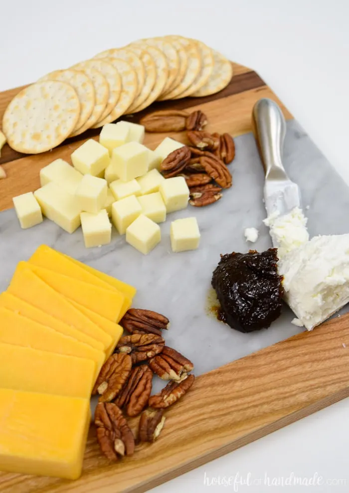 Create a super easy cheese plate with this beautiful homemade marble cheese board. It is so easy to make a wood and marble cutting board. housefulofhandmade.com