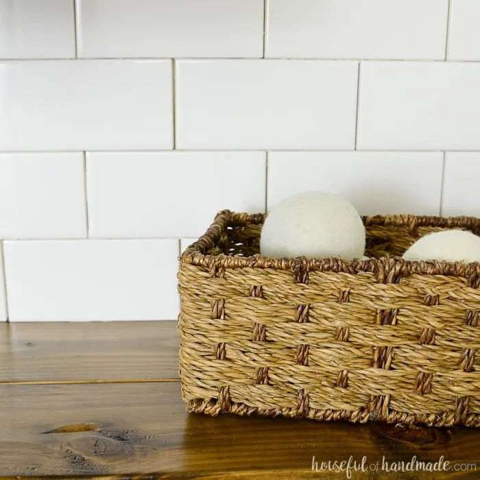 Dryer balls in a basket in the farmhouse laundry room. Housefulofhandmade.com