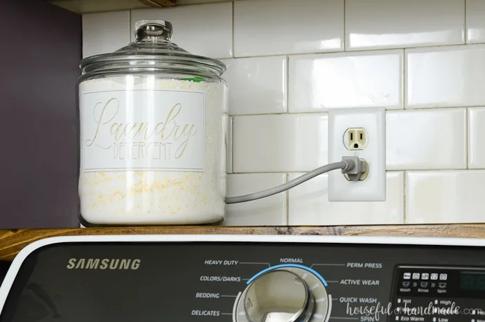 Laundry detergent stored in a glass jar with white label for the farmhouse laundry room reveal. Housefulofhandmade.com