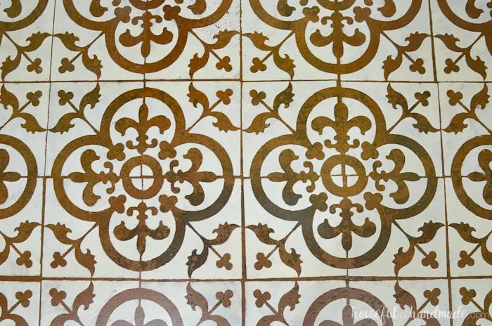 These faux patterned tiles were painted on a concrete basement floor. It looks so amazing and was transformed for only $19 with a floor stencil. Housefulofhandmade.com