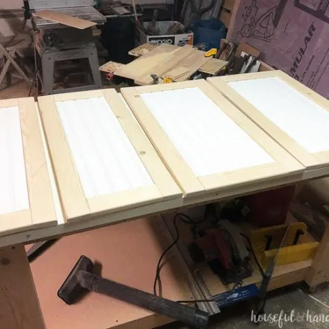 Four DIY shaker cabinet doors with beadboard panels in the workshop. Housefulofhandmade.com