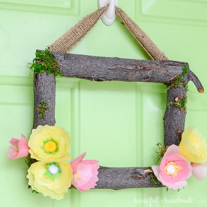 Square wreath made out of branches and tissue paper flowers to make a spring flower wreath. Housefulofhandmade.com