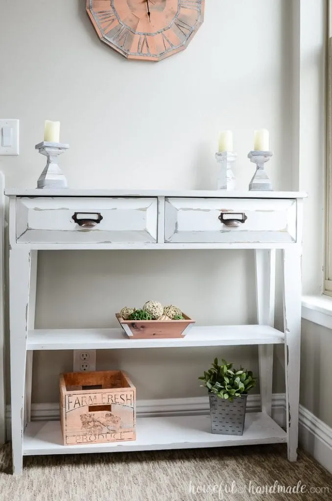 White painted small console table with 2 drawers and open shelving.