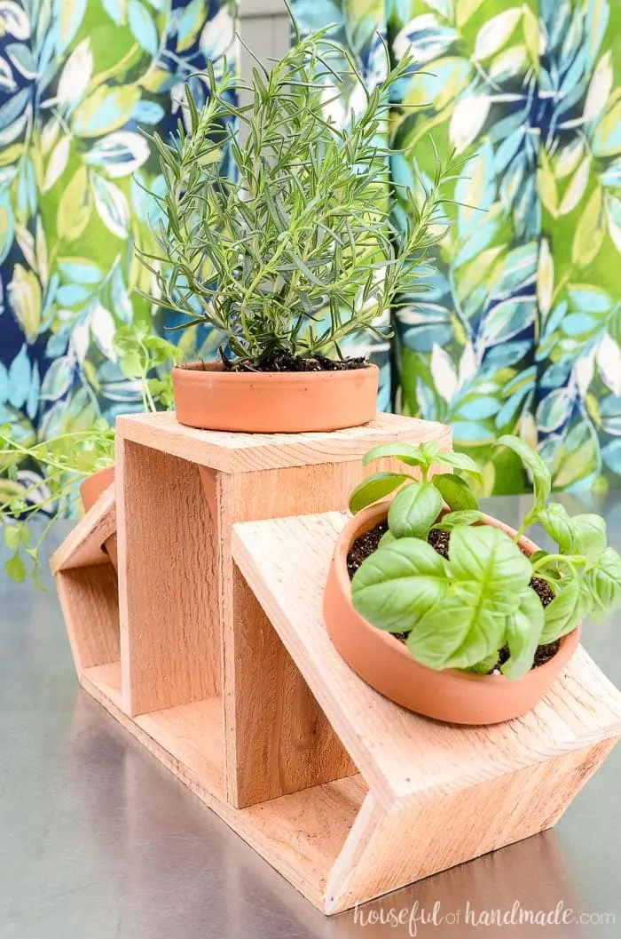 Three terra cotta pots holding herbs in a cedar countertop herb garden. Housefulofhandmade.com