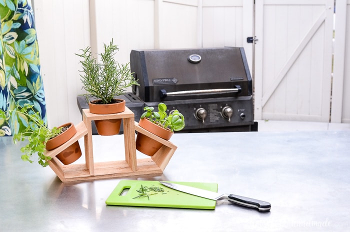 Create a countertop herb garden with this 15 minute craft. Clay pots and a cedar fence picket are turned into a beautiful kitchen herb planter. Use it for a beautiful indoor herb garden or as a fun tabletop garden for your patio. Housefulofhandmade.com