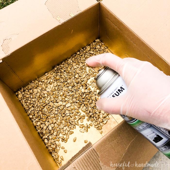 Easily paint decorative rocks for the air plant holder with gold spray paint and a box. Housefulofhandmade.com