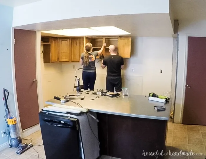 Taking down kitchen cabinets without damaging them is easy. You just need to find the screws that attach them to the walls and join the face frames. See how we are remodeling our kitchen on a budget in 6 weeks. Housefulofhandmade.com