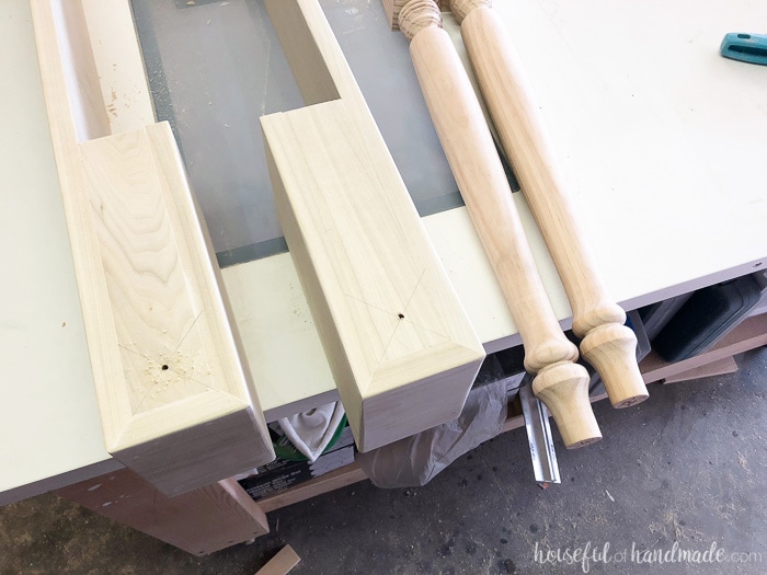 Table legs being attached to a thick base for the kitchen island makeover.