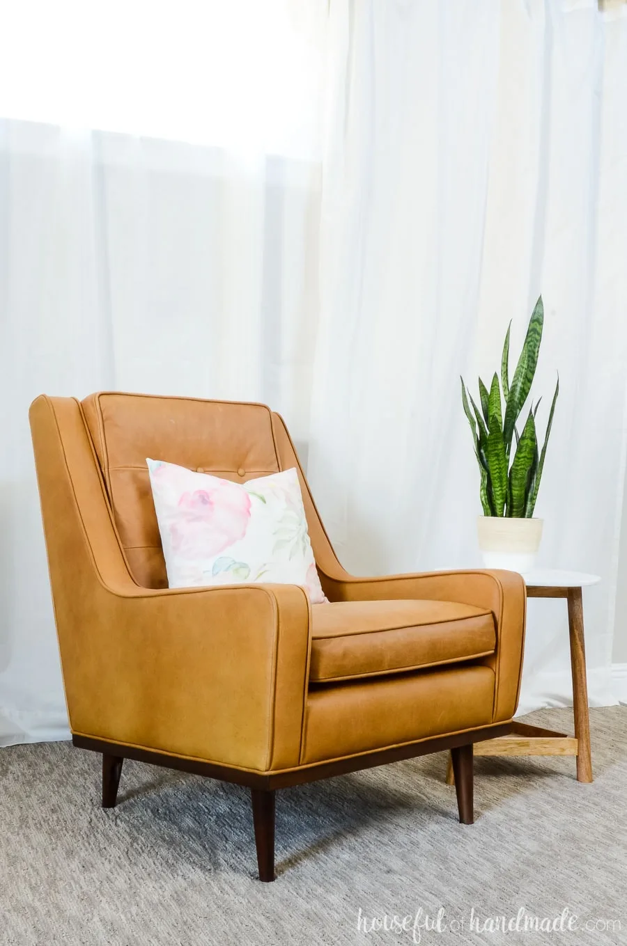Leather is a great option for furniture that can hold up for years. We gave this tan leather armchair a feminine look and did a complete living room refresh for spring. See the details at Housefulofhandmade.com.