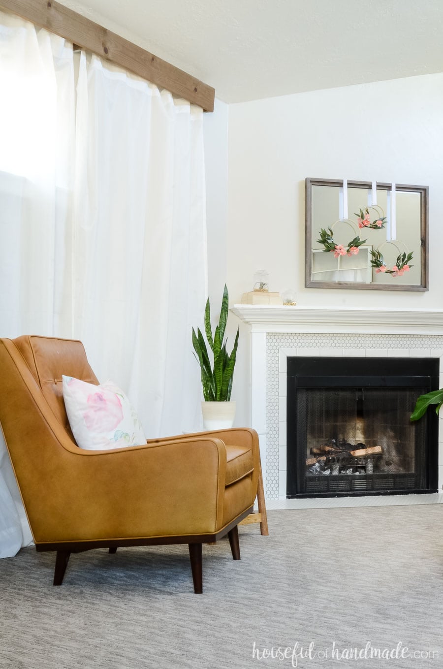 Tan leather armchair in front of a vintage inspired fireplace. See how we updated our living room for spring on a budget. Housefulofhandmade.com