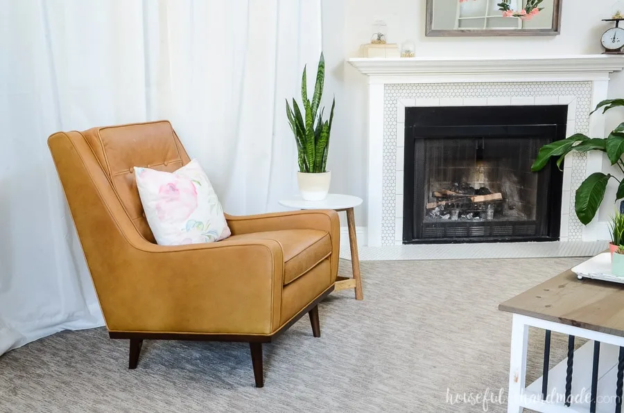 Nina Charme tan leather armchair from Article.com is the perfect small scale chair to put next to our fireplace. Lots of plants give the room a comfortable and warm feel. Housefulofhandmade.com