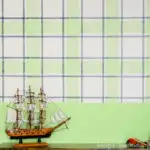 Toy pirate ship on top of the toy console in front of a navy & green plaid wall design.