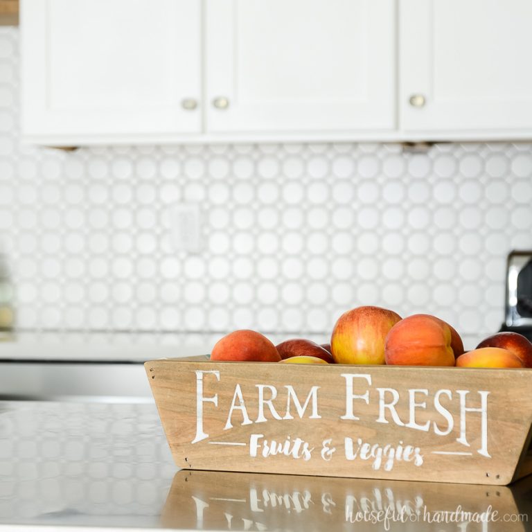 Wood farm fresh produce basket with fabric sling full of fruits.